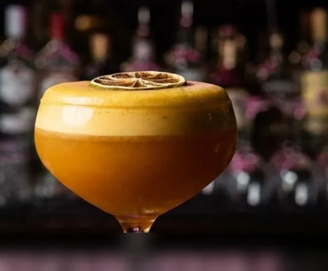 Cóctel de la casa con espuma cítrica sobre la barra